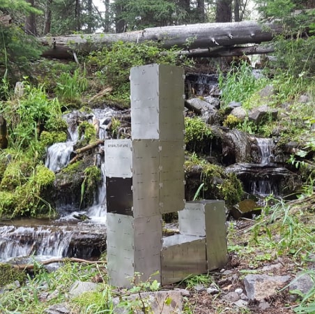 A StealthFyre Deuce assembled as a tall tower stove beside a waterfall