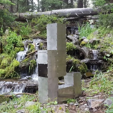 A StealthFyre Deuce assembled as a tall tower stove beside a waterfall