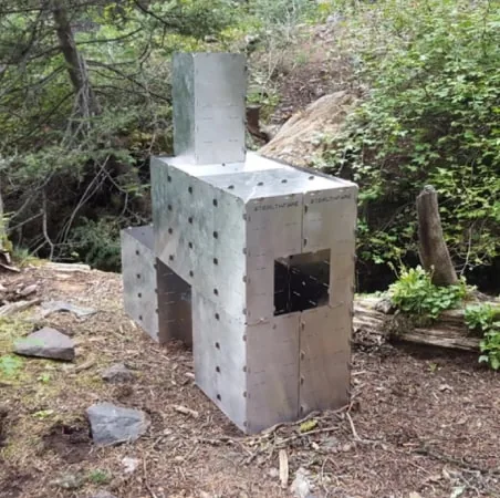 A large StealthFyre Guerrilla Master build with a tall stack on top, assembled in a wooded gully