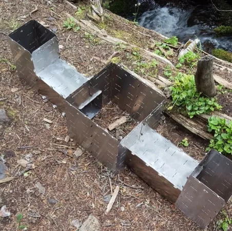 A StealthFyre Origin Deluxe assembled into a multi-unit cooking layout beside a creek