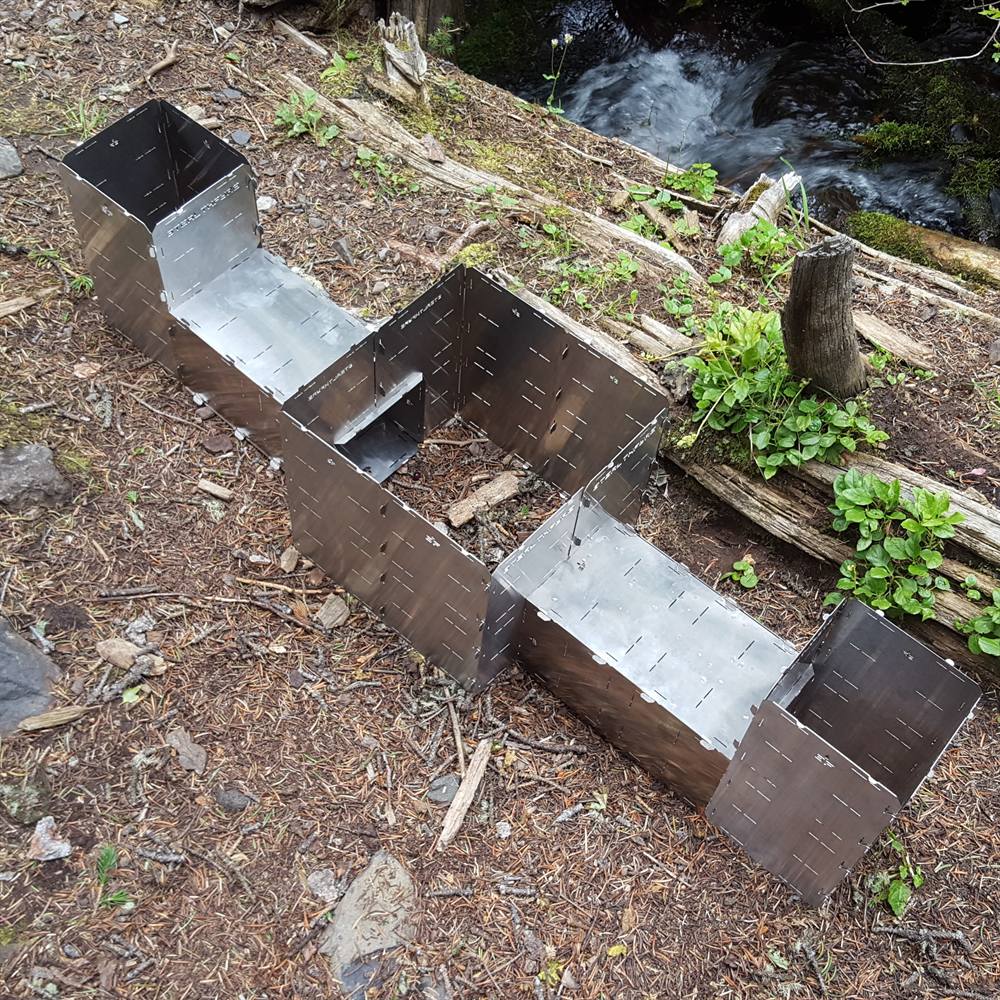 Several StealthFyre units assembled side by side from the same interlocking panels, set up on a creek bank